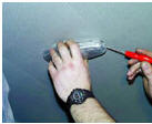 2. Отжать с помощью отвертки фиксирующую пружину